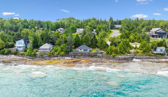 Seafari is a charming stone cottage on Georgian Bay with stunning bluff views, a flat rock shoreline, and a cozy bunkie. Perfect for relaxing, swimming, and exploring.
